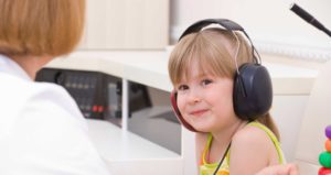 young girl with over-ear headphones on.